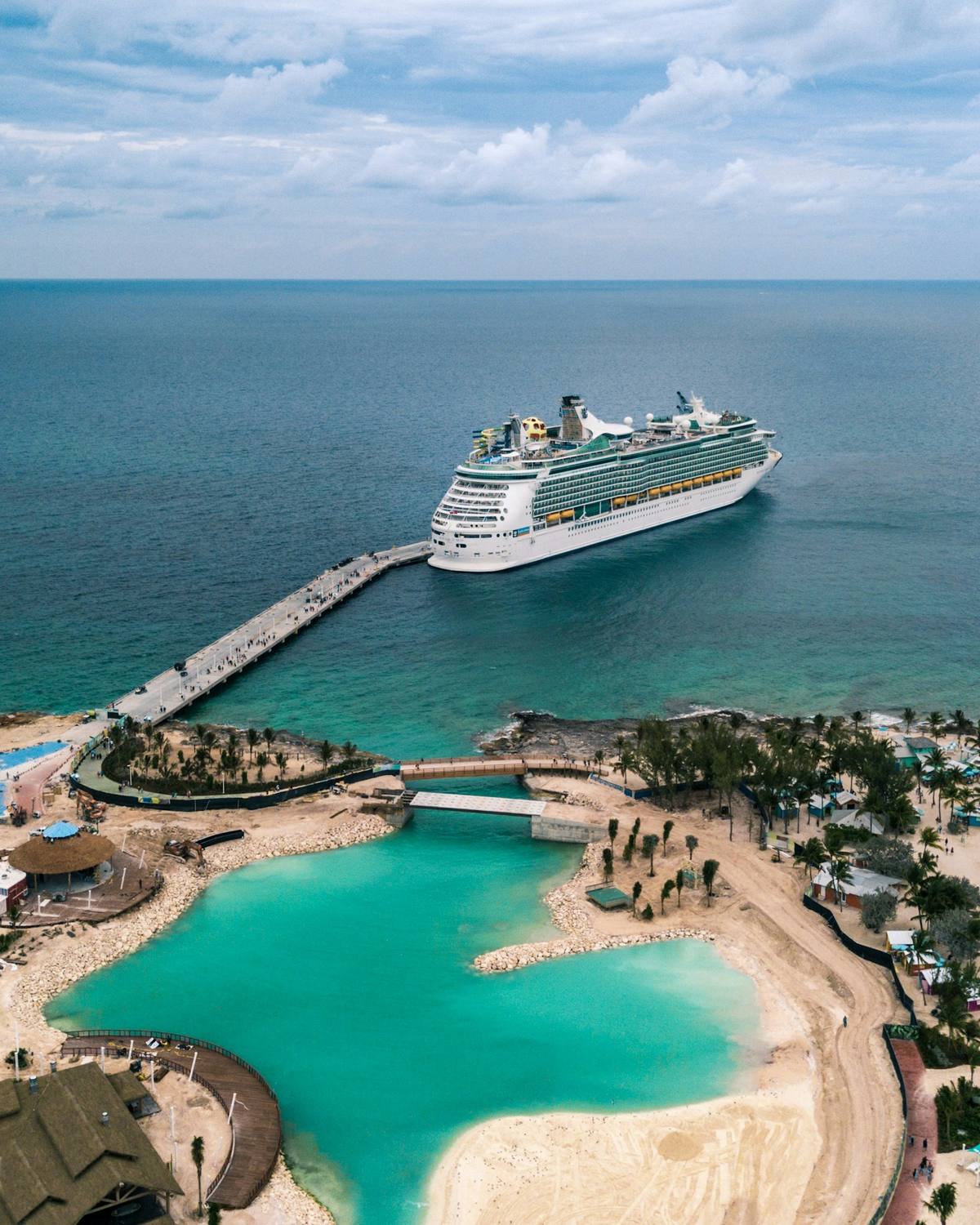 A cruise ship docked beside a private island