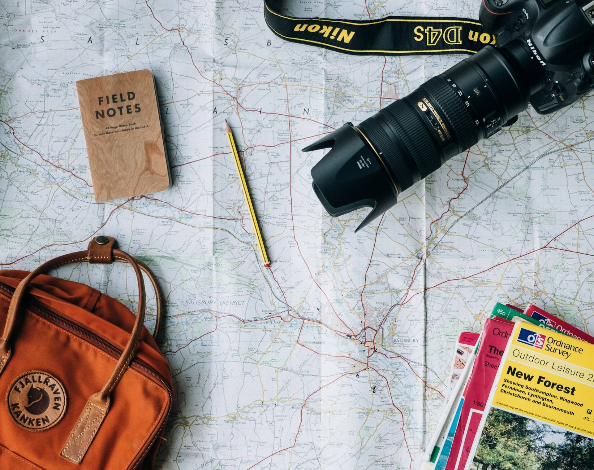 A map, camera, and travel gear laid out for trip planning