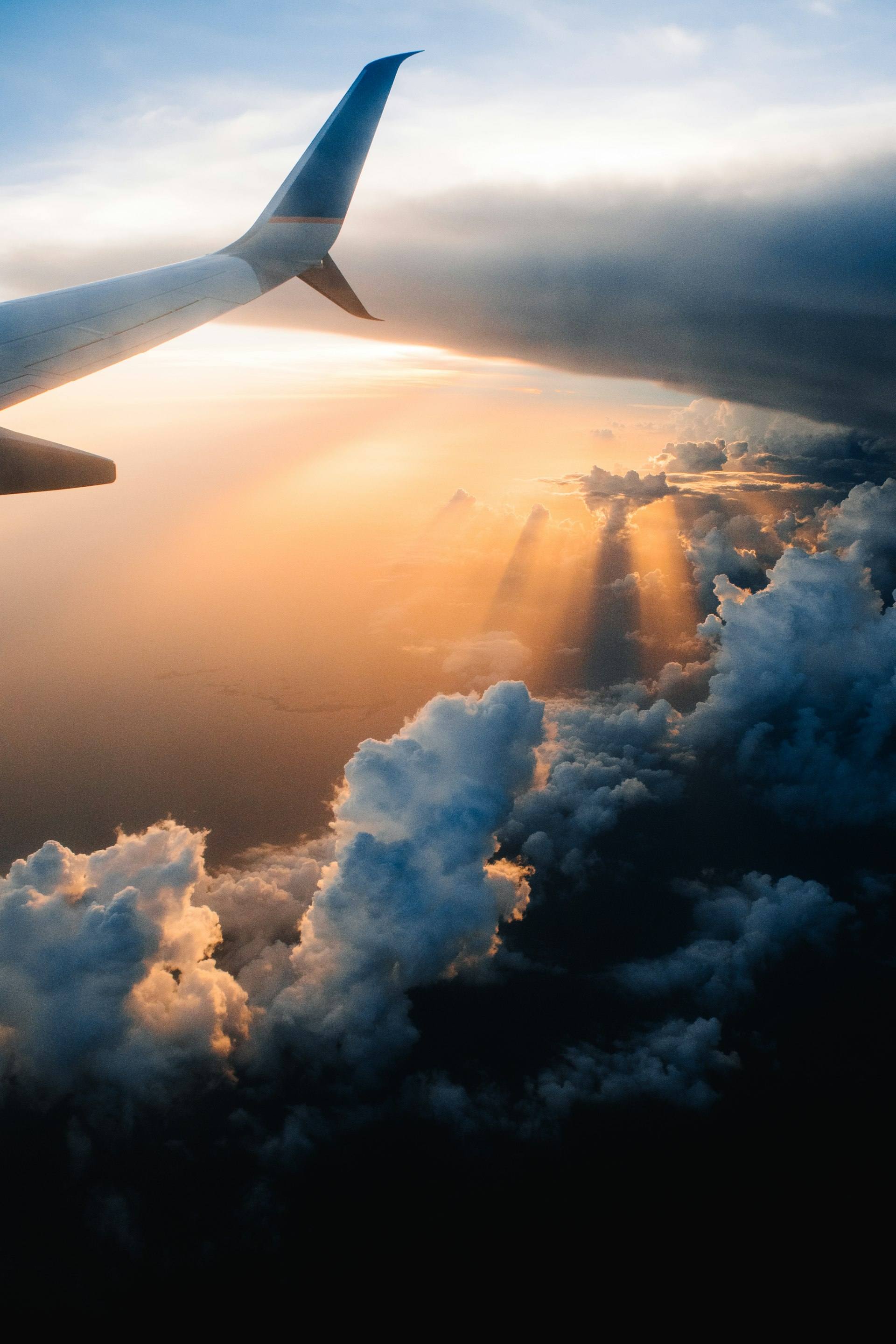 View of golden clouds from an airplane window at sunset