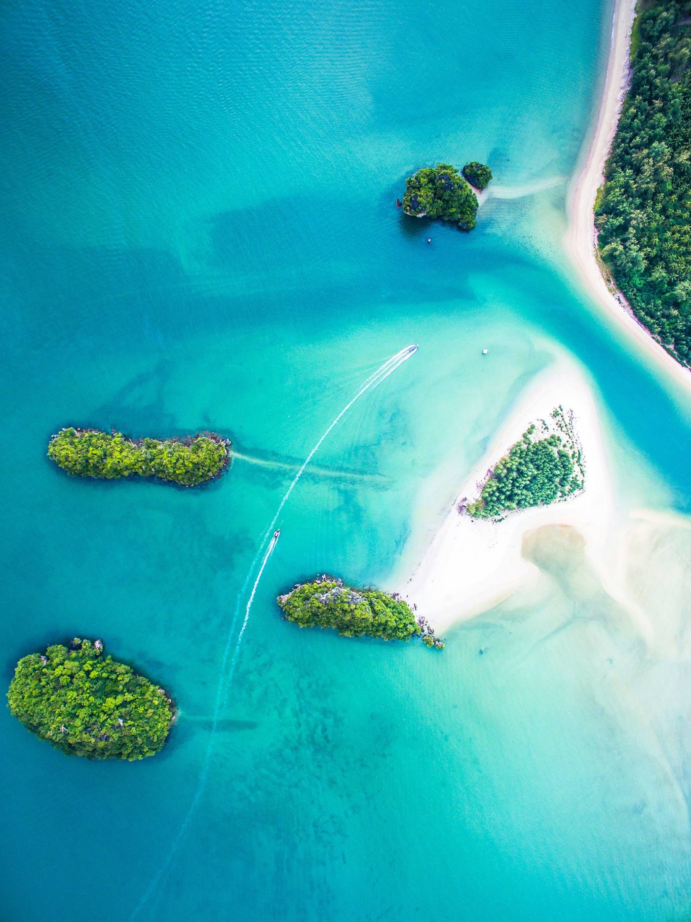 Aerial view of turquoise water and small green islands in the Caribbean